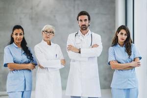 Team Of Doctors And Nurses Standing With Arms Crossed And Looks At Camera photo