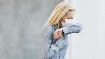 A Business Woman With Protective Mask Coughs At The Elbow During Coronavirus Pandemic