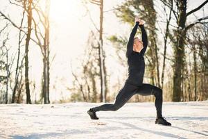 Man Doing Workout In The Forest In A Snowy Winter Day photo