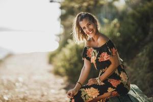 mujer con vestido de flores disfrutando en el bosque de pinos foto