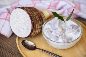 Taro food with dessert taro boiled with sugar and coconut milk on bowl and fresh raw organic taro root ready to cook, Asian Thai food photo