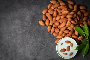 Almond milk and Almonds nuts on dark background, Delicious sweet almonds on table, roasted almond nut for healthy food and snack - top view photo