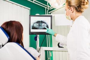 dentista mostrando al paciente una imagen de rayos x foto