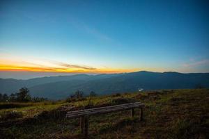 Sunset or sunrise on viewpoint hill mountain yellow and blue sky and bamboo bench photo