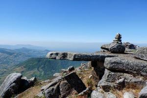 paisaje hermosa roca de piedra en la cima de la colina montaña cielo azul foto