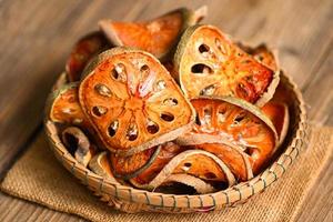 Dried bael slices on basket background, Bael for bael juice - Dry bael fruit tea for health - Aegle marmelos photo