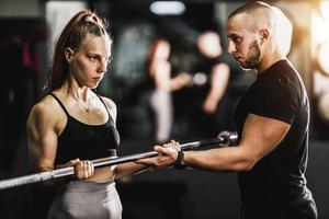 Woman Doing Hard Training With Coach At The Gym photo