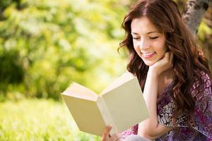 retrato de niña con un libro en el parque foto