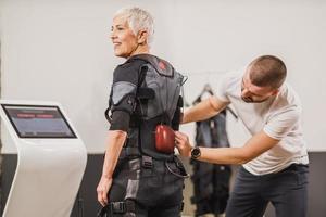 Fitness Instructor Putting An Ems Suit To A Woman photo