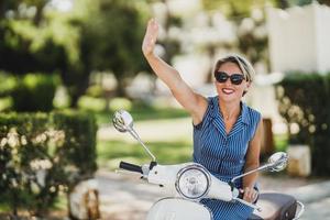 Woman Riding A Vintage Scooter And Waving photo