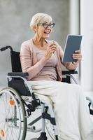 Disabled Senior Woman Using Digital Tablet photo
