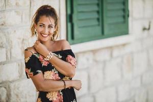 mujer sonriente con vestido de flores se divierte en el día de verano foto