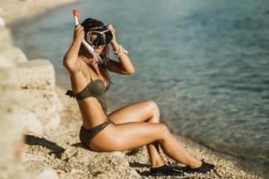 mujer con máscara y snorkel preparándose para bucear foto