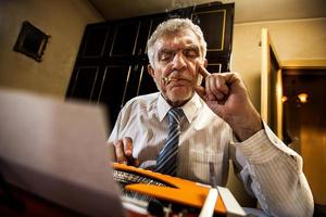 Senior Man Writing On A Typewriter photo