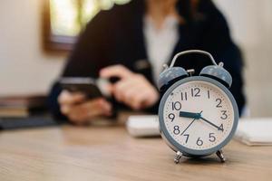 Alarm clock on the desk. Business working in modern office building or home at night using laptop. photo