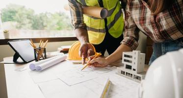 personas de ingeniería que se reúnen trabajando en oficinas modernas para discutir, ingeniería. manos de ingenieros que trabajan en el concepto de construcción de planos. foto