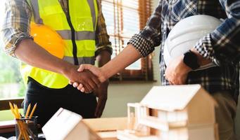 Engineer and contractor join hands after signing contract,They are having a building project together. successful cooperation concept photo