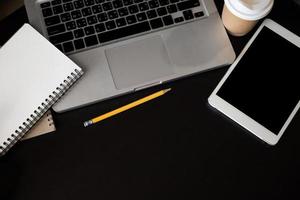 office desk table with a lot of things tablet, laptop ,smartphone ,notepad and coffee cup notepad . Top view with copy space photo