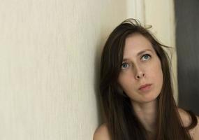 portrait of a girl with long hair, with a sad look. A young girl is depressed, copy space. Disorder of mental health. Pensive look up photo