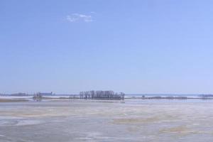 panorama invernal del volga congelado contra el fondo del cielo azul y las nubes en los brillantes rayos de la luz del día. foto