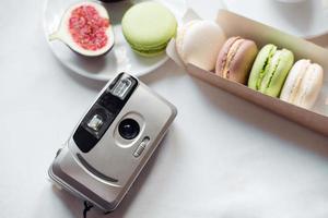 aesthetic film camera flatley, figs and macarons on white background, top view