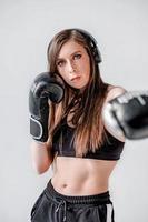 boxer girl. the girl strikes. shadow-boxing. boxing. women's boxing. girl with boxing gloves. crop top for sports. the girl's press. strong face photo