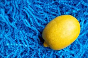 limones sobre un fondo azul con copyspace. limón en una caja de regalo azul foto