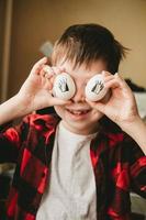 imagen divertida de un niño con huevos en lugar de ojos. huevos con ojos pintados. preparándose para la pascua. divertido cocinar con los niños foto