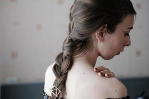 girl with a classic braid, with bare shoulders, rear view photo