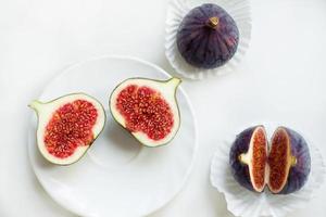 cut and whole figs on a plate, On a white background. Flat lay, Top view. Copy space. photo