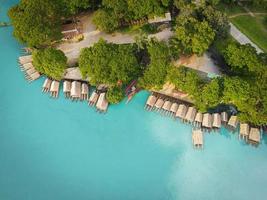 Aerial view blue water river, Top view sea blue lagoon pond water from above, Bird eye view green tree and bamboo raft house and wooden boat on water surface beautiful fresh environment landscape lake photo