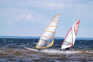 Tolyatti, Samara region, 2020 - A pair of windsurfers riding the waves. photo