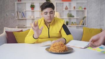 a criança com sobrepeso quer perder peso. a criança obesa não quer comer o macarrão que vem na frente dela video