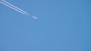 scie di condensazione nel cielo azzurro di agosto. aereo che vola alto. video