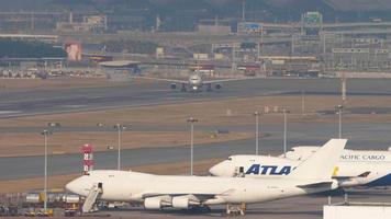 HONG KONG NOVEMBER 10, 2019 - Cargo aircraft parking. Boeing 747 cargo in the parking lot of the cargo terminal, in the background the plane is taxiing for takeoff video
