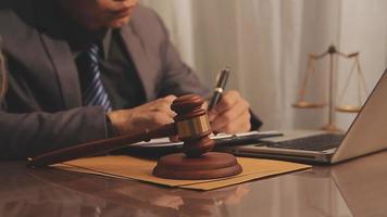 Business and lawyers discussing contract papers with brass scale on desk in office. Law, legal services, advice, justice and law concept video