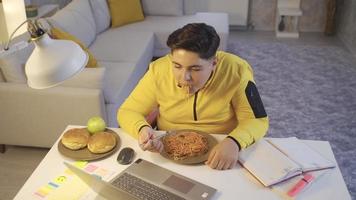 el niño que dejó de comer por su peso. niño comiendo pasta mientras estudia. deja de comer y se mira la barriga. video