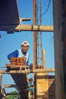 Tegal, Jawa Tengah, 2022 - construction workers install bricks and cement from rows of bricks on exterior walls photo