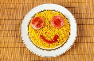 yellow rice on a plate with sausage in the form of eyes, fun food photo