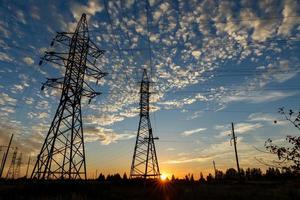 High voltage power line supports at sunset photo