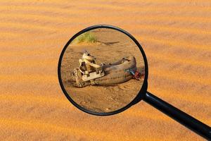 saddle for camel on the sand, view through a magnifying glass against the background of sand photo