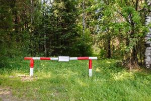 Red-white barrier in the forrest. photo