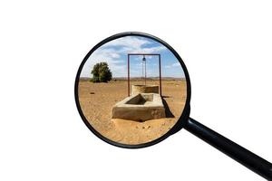 water well in the Sahara desert, view through a magnifying glass on a white background photo