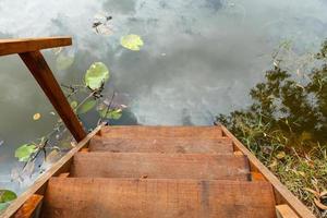 wooden ladder for swimming descending to lake photo