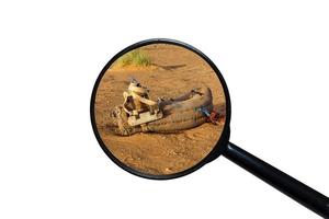 saddle for camel on the sand, view through a magnifying glass on a white background photo