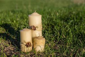 three decorative wax candles on a green lawn photo