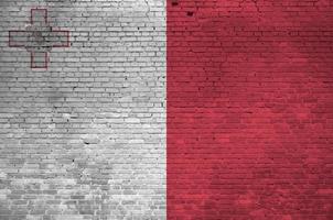 Malta flag depicted in paint colors on old brick wall. Textured banner on big brick wall masonry background photo