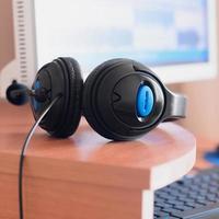 Big black headphones lie on the wooden desktop of the sound designer photo