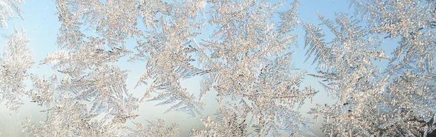 Snowflakes frost rime macro on window glass pane photo