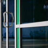 Chrome door handle and glass of modern aluminium office facade photo